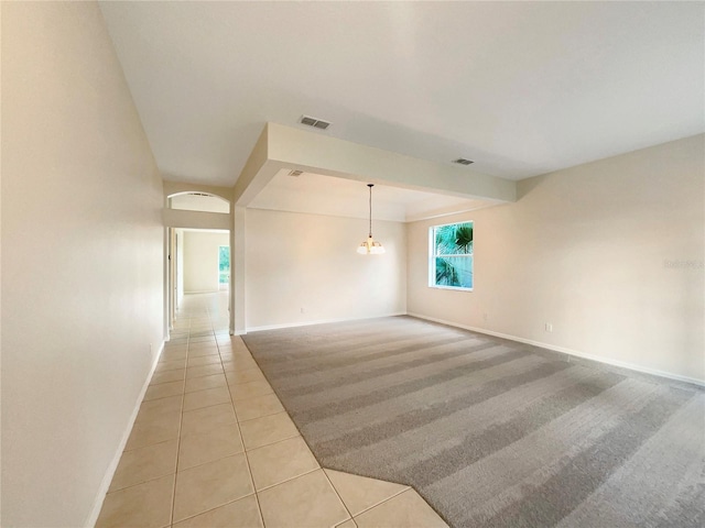 tiled empty room with a chandelier