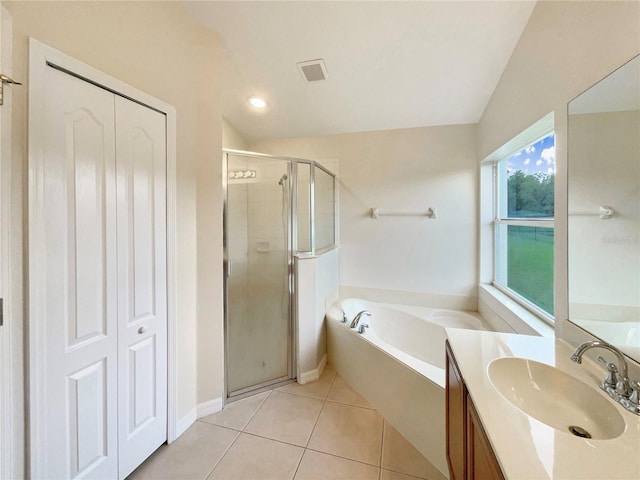 bathroom with shower with separate bathtub, vanity, vaulted ceiling, and tile patterned floors