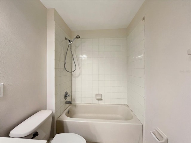 bathroom with tiled shower / bath combo and toilet