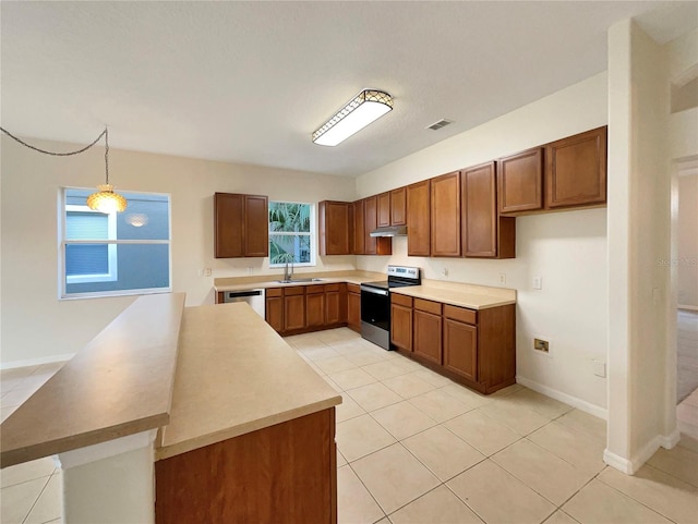 kitchen featuring sink, light tile patterned floors, stainless steel appliances, and decorative light fixtures