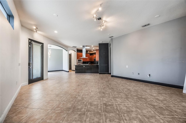 unfurnished living room with a textured ceiling and light tile patterned flooring