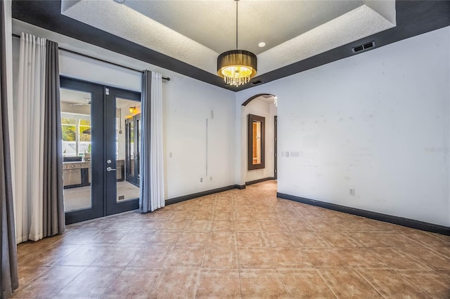 unfurnished room with french doors and a textured ceiling