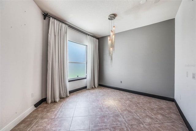 tiled empty room featuring baseboards