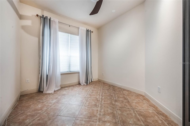 empty room with ceiling fan, light tile patterned flooring, and baseboards