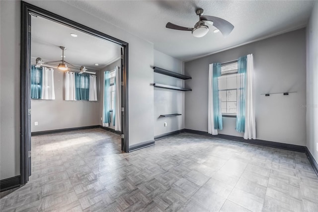 unfurnished room featuring a ceiling fan, a textured ceiling, baseboards, and light floors