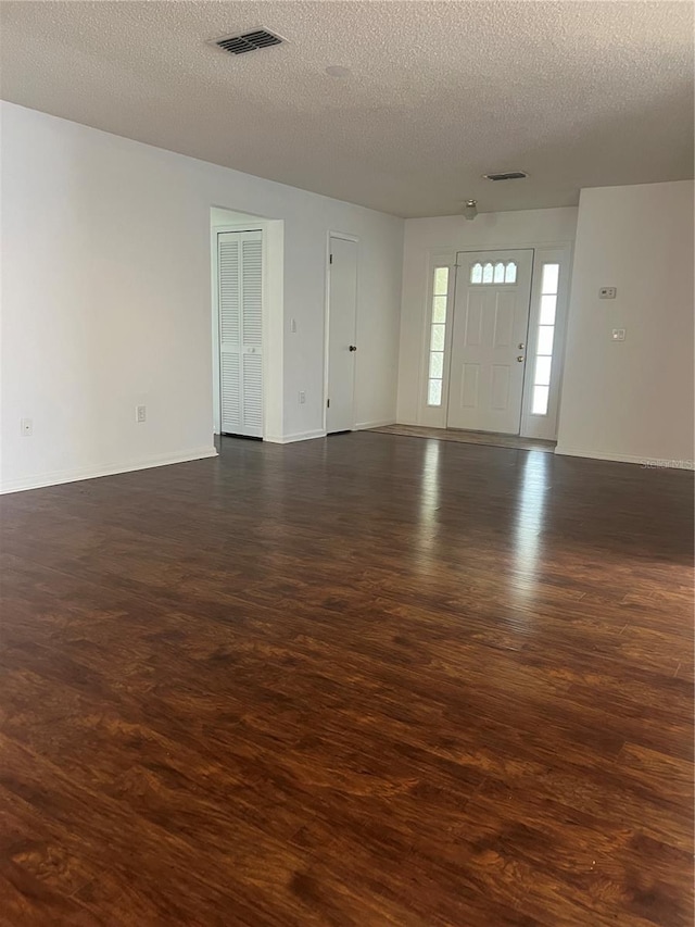 interior space featuring dark hardwood / wood-style flooring and a textured ceiling