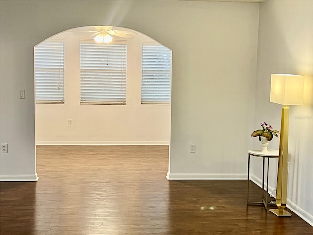 empty room with ceiling fan and dark wood-type flooring