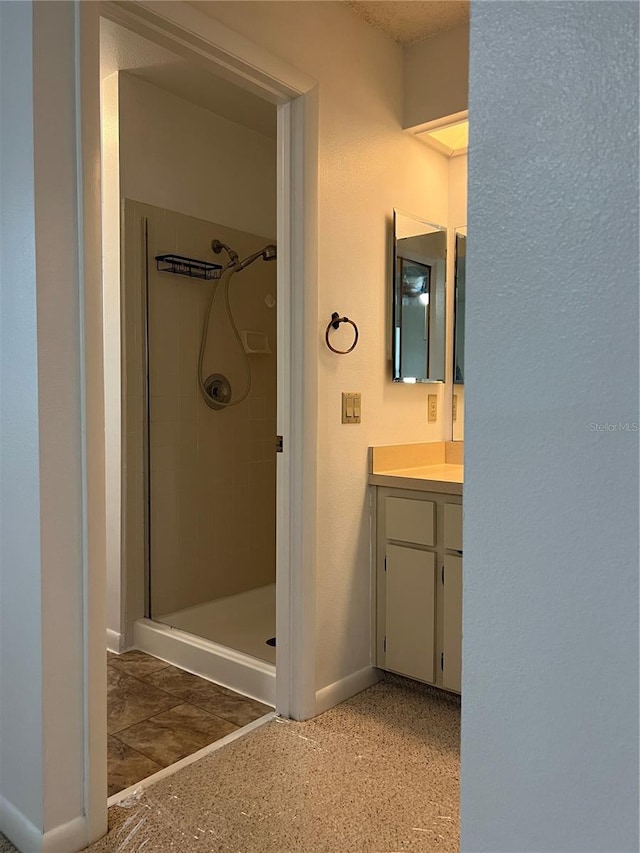 bathroom with vanity and tiled shower