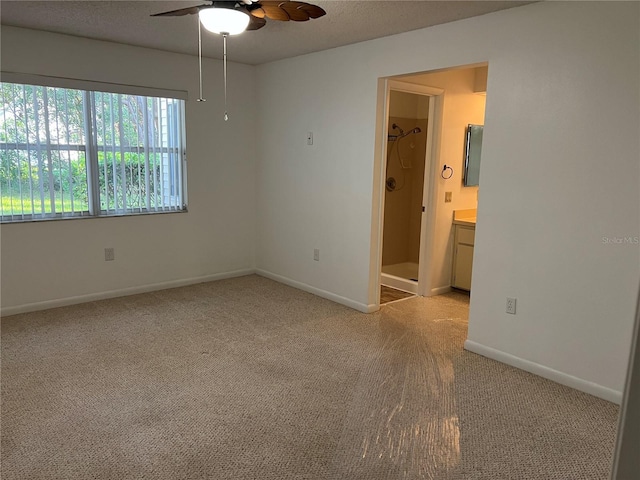 empty room with a textured ceiling, light colored carpet, and ceiling fan