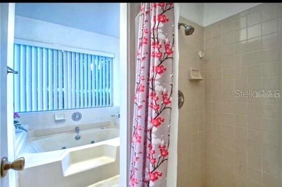 bathroom featuring shower with separate bathtub