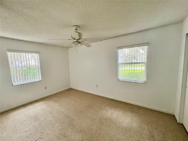 empty room with ceiling fan, carpet floors, and a textured ceiling