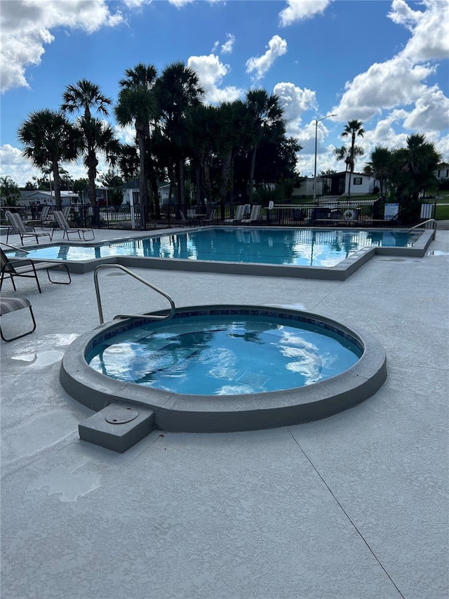 view of pool featuring a community hot tub and a patio