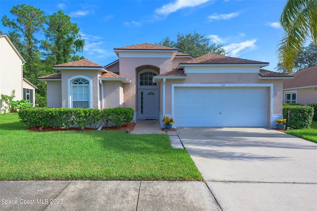 mediterranean / spanish home with a garage and a front lawn