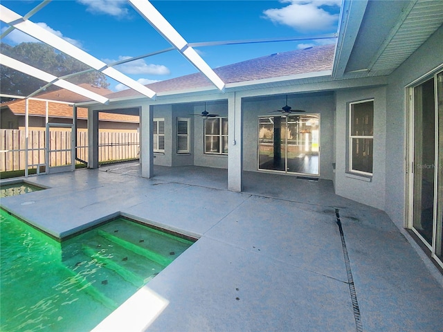 view of pool featuring a patio, glass enclosure, and ceiling fan