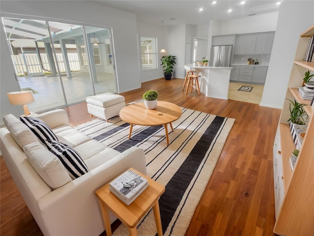 living area with recessed lighting and light wood-style floors