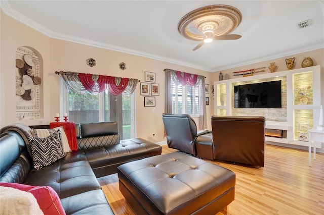 living room featuring wood-type flooring, ornamental molding, and a healthy amount of sunlight