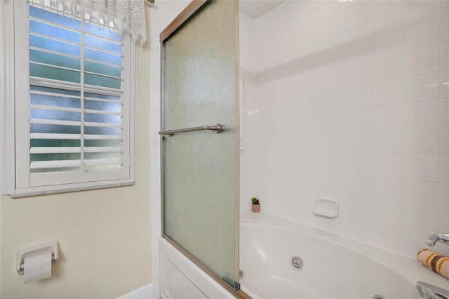 bathroom with bath / shower combo with glass door