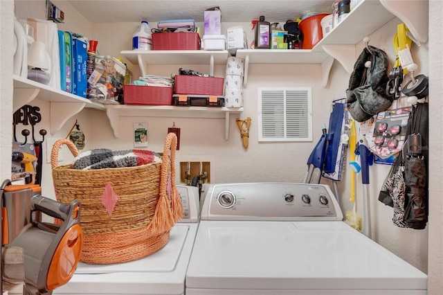 clothes washing area featuring a textured ceiling and washing machine and dryer