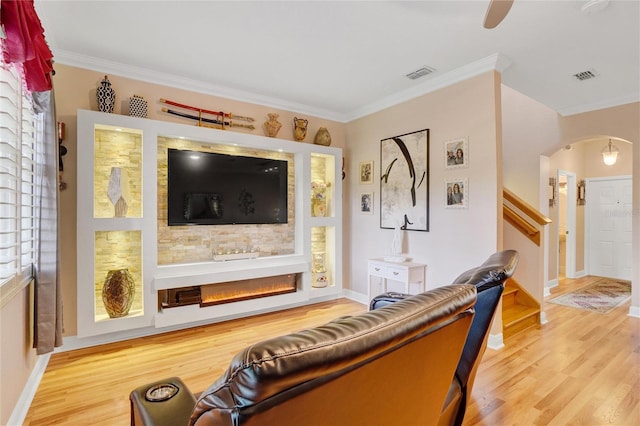 living room with crown molding and light hardwood / wood-style floors