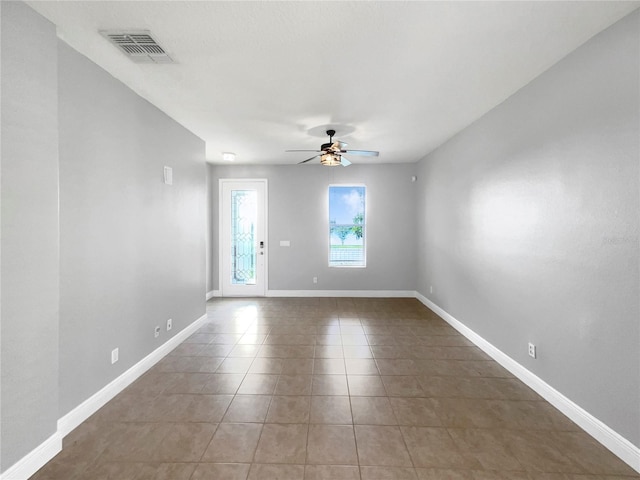 tiled empty room featuring ceiling fan