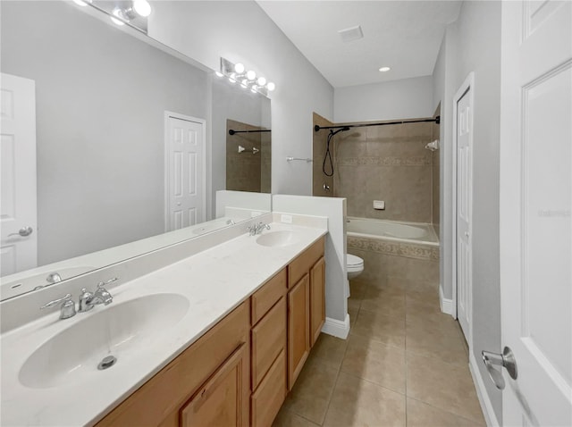 full bathroom with tile patterned floors, tiled shower / bath combo, vanity, and toilet