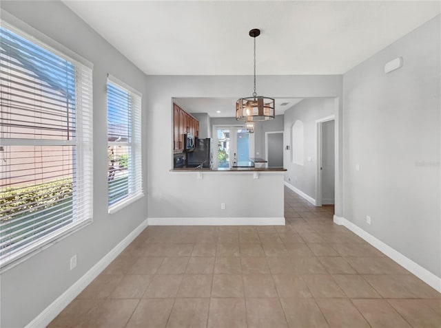 interior space with light tile patterned floors and a notable chandelier