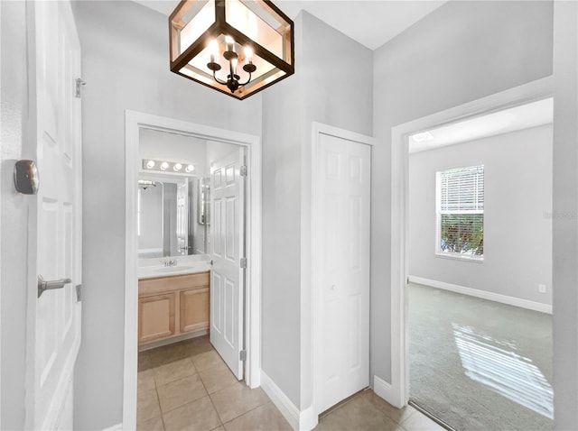 bathroom with a notable chandelier, tile patterned flooring, and vanity