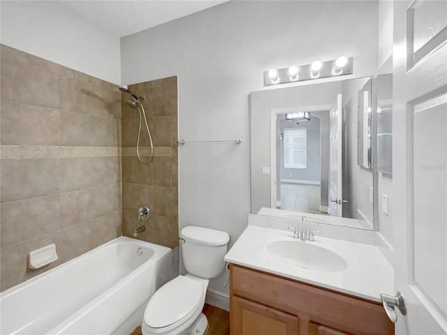 full bathroom featuring tiled shower / bath, vanity, and toilet