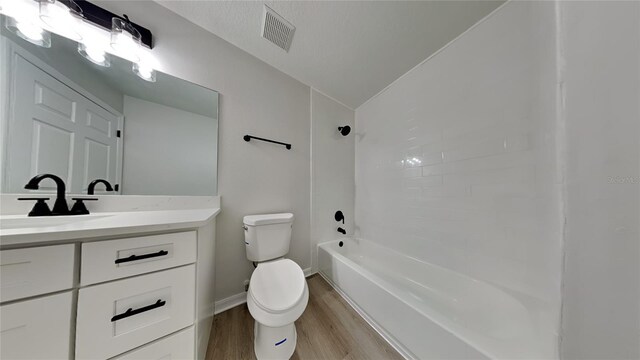 full bathroom with vanity, wood-type flooring, lofted ceiling, shower / tub combination, and toilet