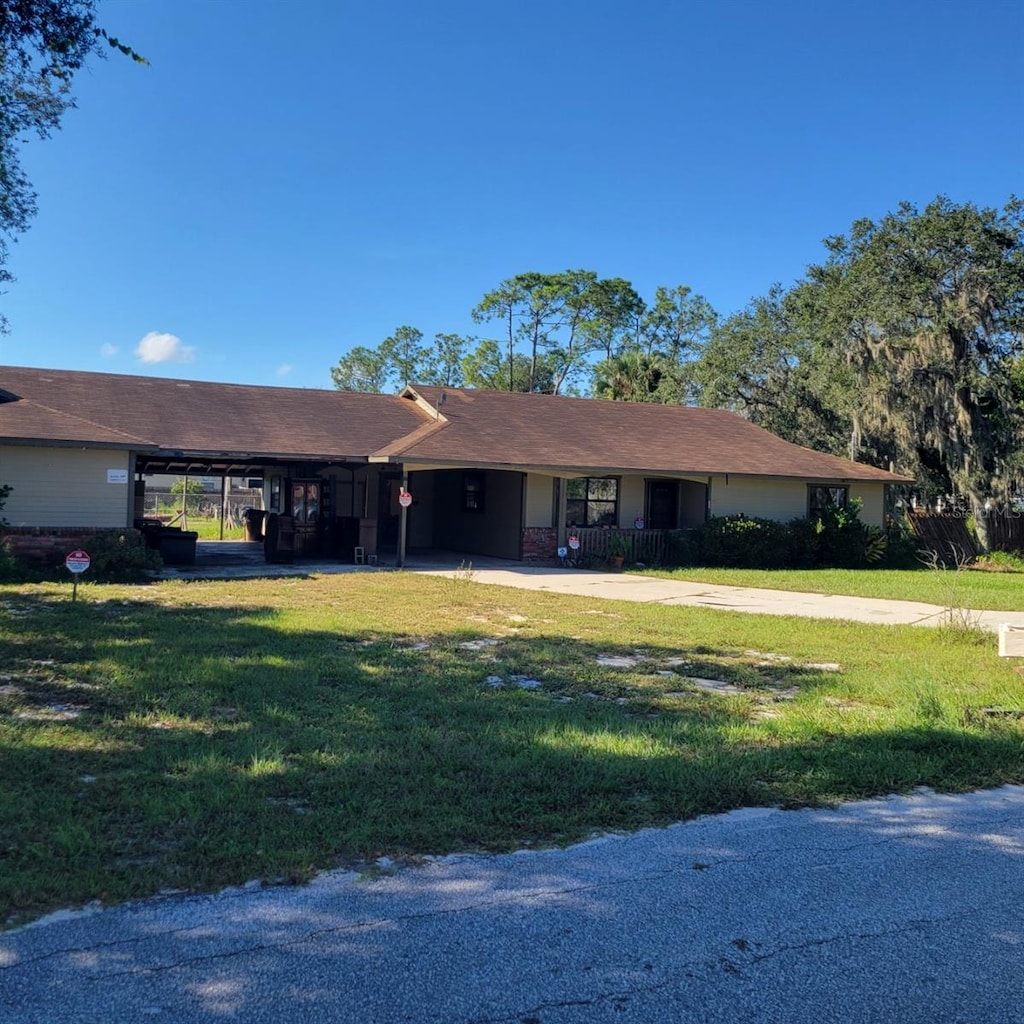 single story home with a front yard and a carport