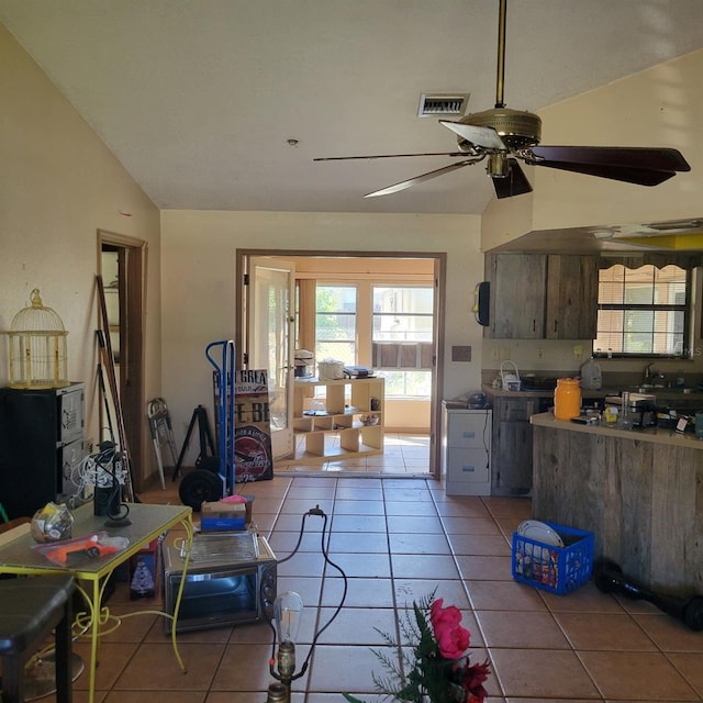 kitchen with vaulted ceiling, ceiling fan, light tile patterned floors, and sink