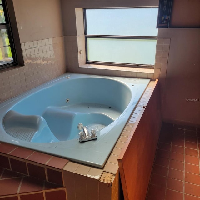 bathroom with tile patterned floors, plenty of natural light, and a relaxing tiled tub