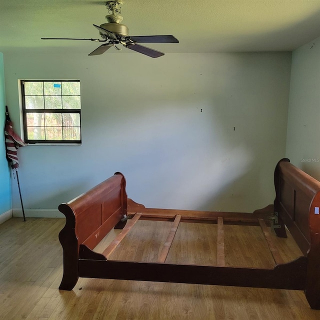 staircase featuring wood-type flooring and ceiling fan