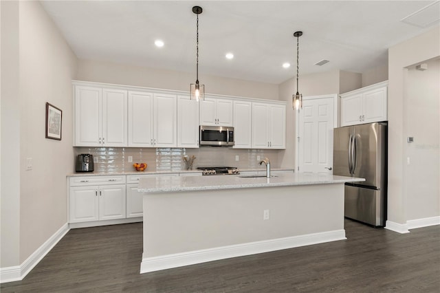 kitchen featuring an island with sink, white cabinetry, appliances with stainless steel finishes, and decorative light fixtures