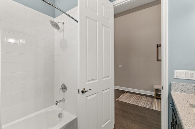 bathroom featuring vanity, tiled shower / bath combo, and hardwood / wood-style flooring