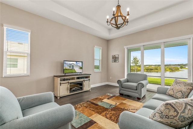 living room featuring an inviting chandelier, a healthy amount of sunlight, and dark hardwood / wood-style flooring