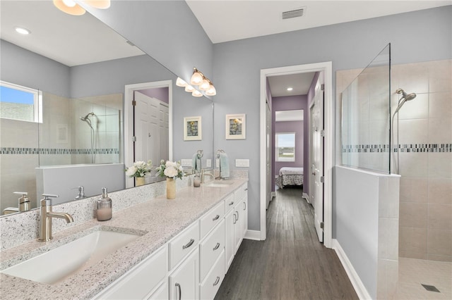 bathroom featuring vanity, hardwood / wood-style flooring, and a tile shower