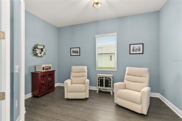 living area featuring dark wood-style flooring and baseboards
