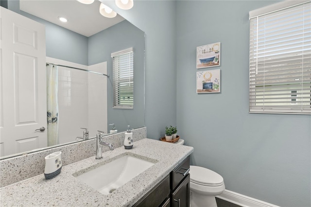 bathroom with baseboards, a shower with shower curtain, toilet, and vanity