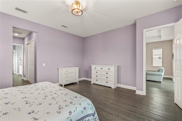 bedroom with dark wood-style floors, visible vents, and baseboards
