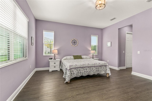 bedroom featuring dark wood-type flooring, visible vents, and baseboards