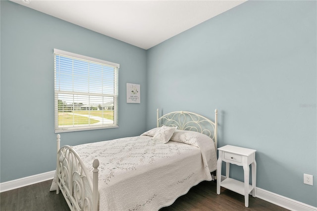 bedroom with baseboards and dark wood-style flooring