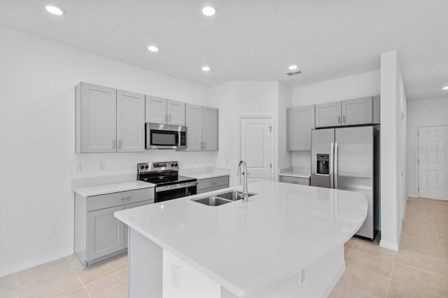 kitchen featuring light countertops, gray cabinets, appliances with stainless steel finishes, and a sink