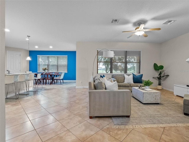 tiled living room with a healthy amount of sunlight and ceiling fan