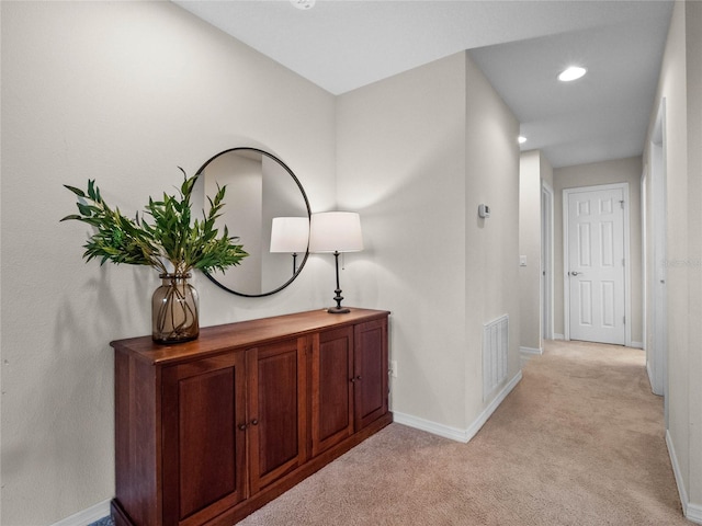 hallway featuring light colored carpet