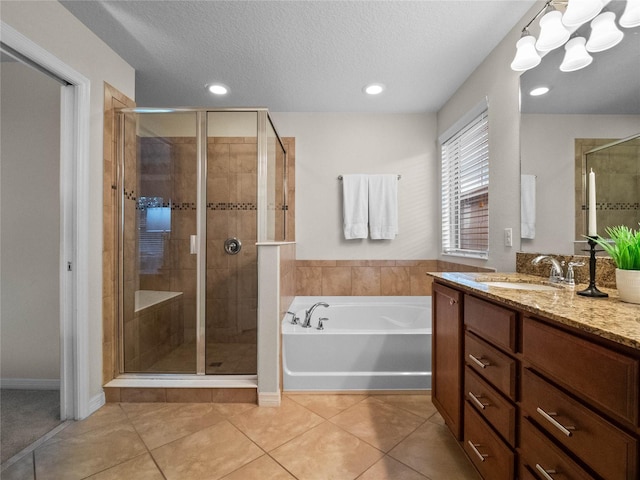 bathroom with plus walk in shower, tile patterned floors, a textured ceiling, and vanity