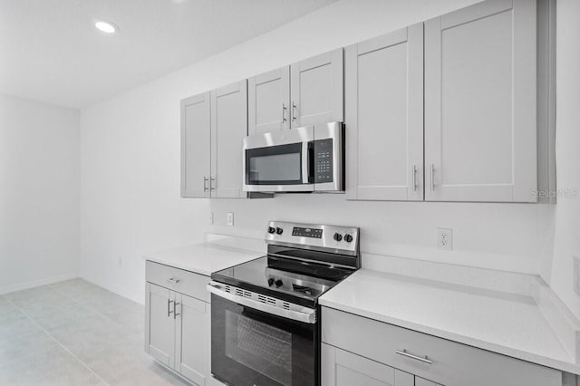 kitchen featuring recessed lighting, appliances with stainless steel finishes, light countertops, and baseboards