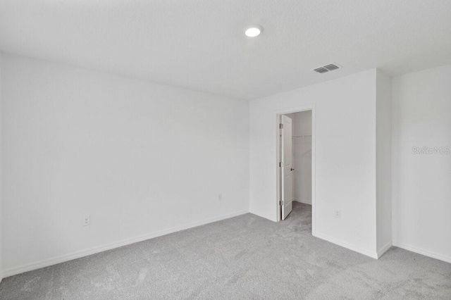 carpeted spare room with baseboards and visible vents