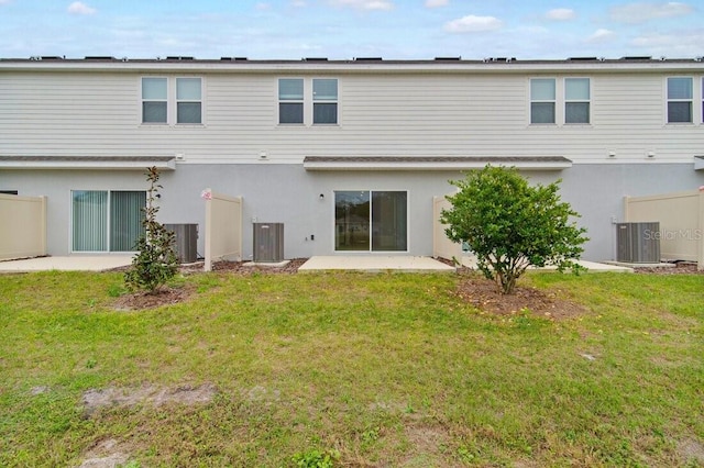 back of house featuring central air condition unit, a patio area, and a lawn