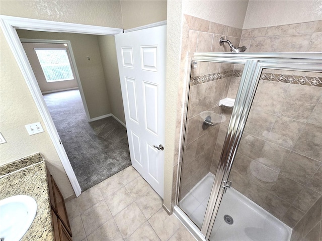 bathroom featuring a shower with shower door and vanity